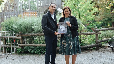 Frau Dietl und Herr Baban halten den Geschäftsbericht 2024 in den Händen.