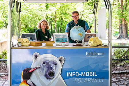 Zwei Ehrenamtliche hinter dem Info-Mobil Polarwelt.