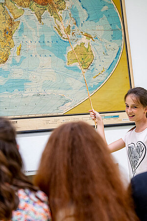 Eine Klasse beim Unterricht in der Tierparkschule, an der Wand eine Weltkarte.