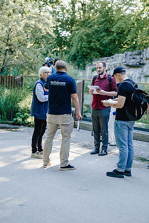 Mehrere Personen stehen vor der Anlage der Humboldtpinguine.