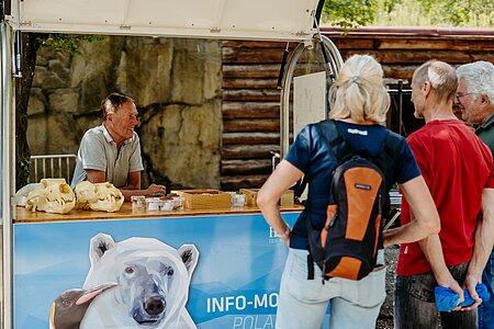 Zwei Artenschutzbotschaftler stehen hinter ihrem Infomobil.