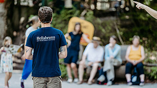 Ein Tierpfleger hält vor Besuchenden einen Tierpflegertreffpunkt