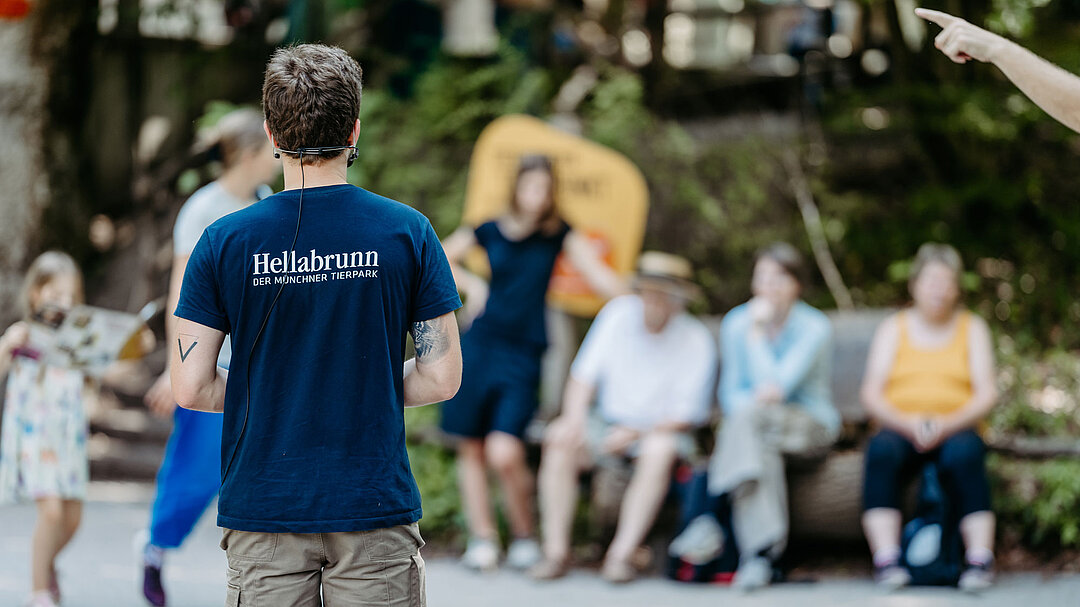 Ein Tierpfleger hält vor Besuchenden einen Tierpflegertreffpunkt