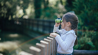 Mädchen mit Fernglas im Tierpark